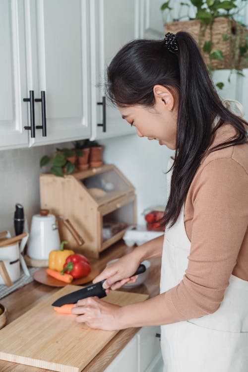 Free Woman in Brown Long Sleeve Shirt and Apron in the Kitchen Stock Photo