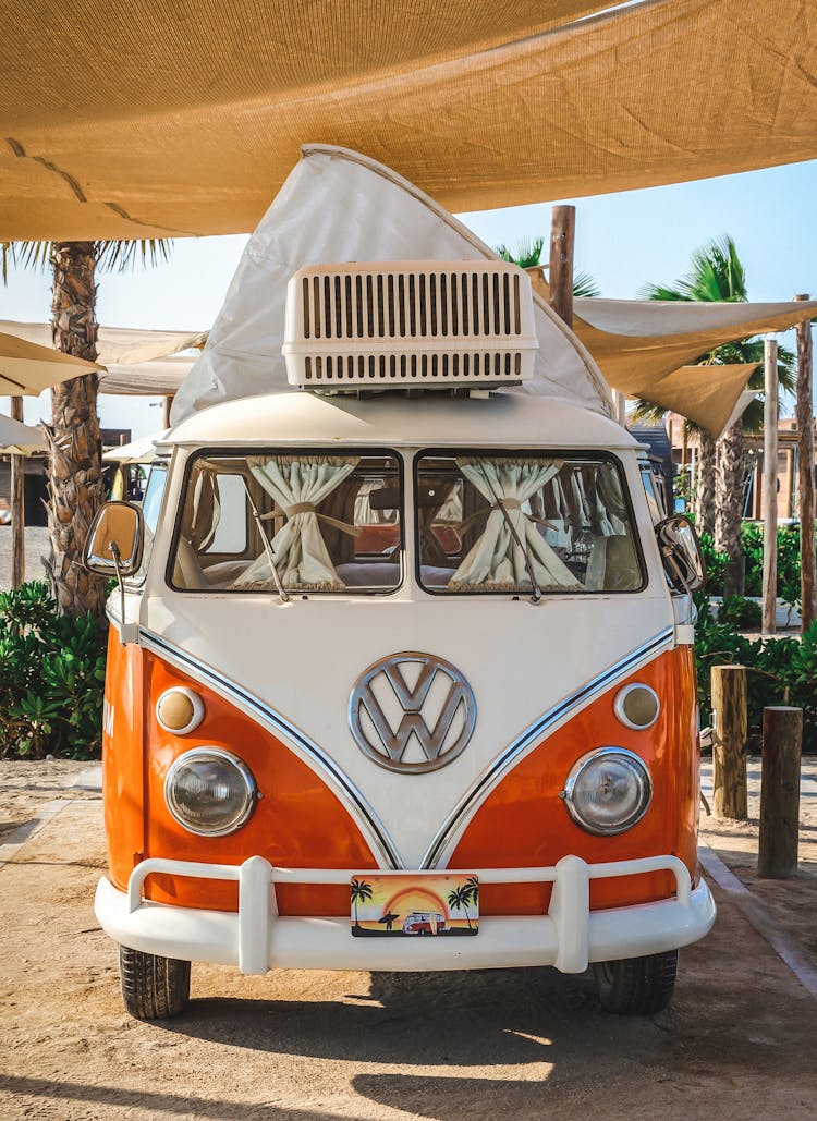 A White And Orange Van Parked On The Street