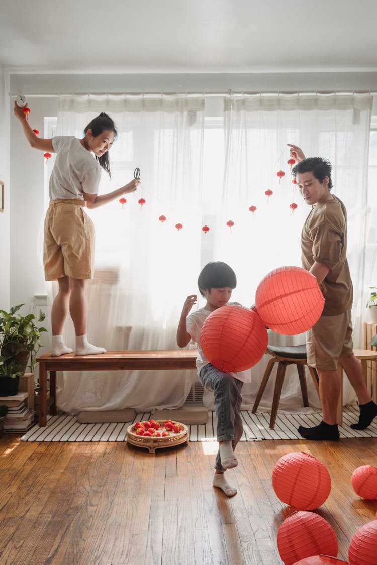 Mother, Father And Their Child Decorating Their Apartment