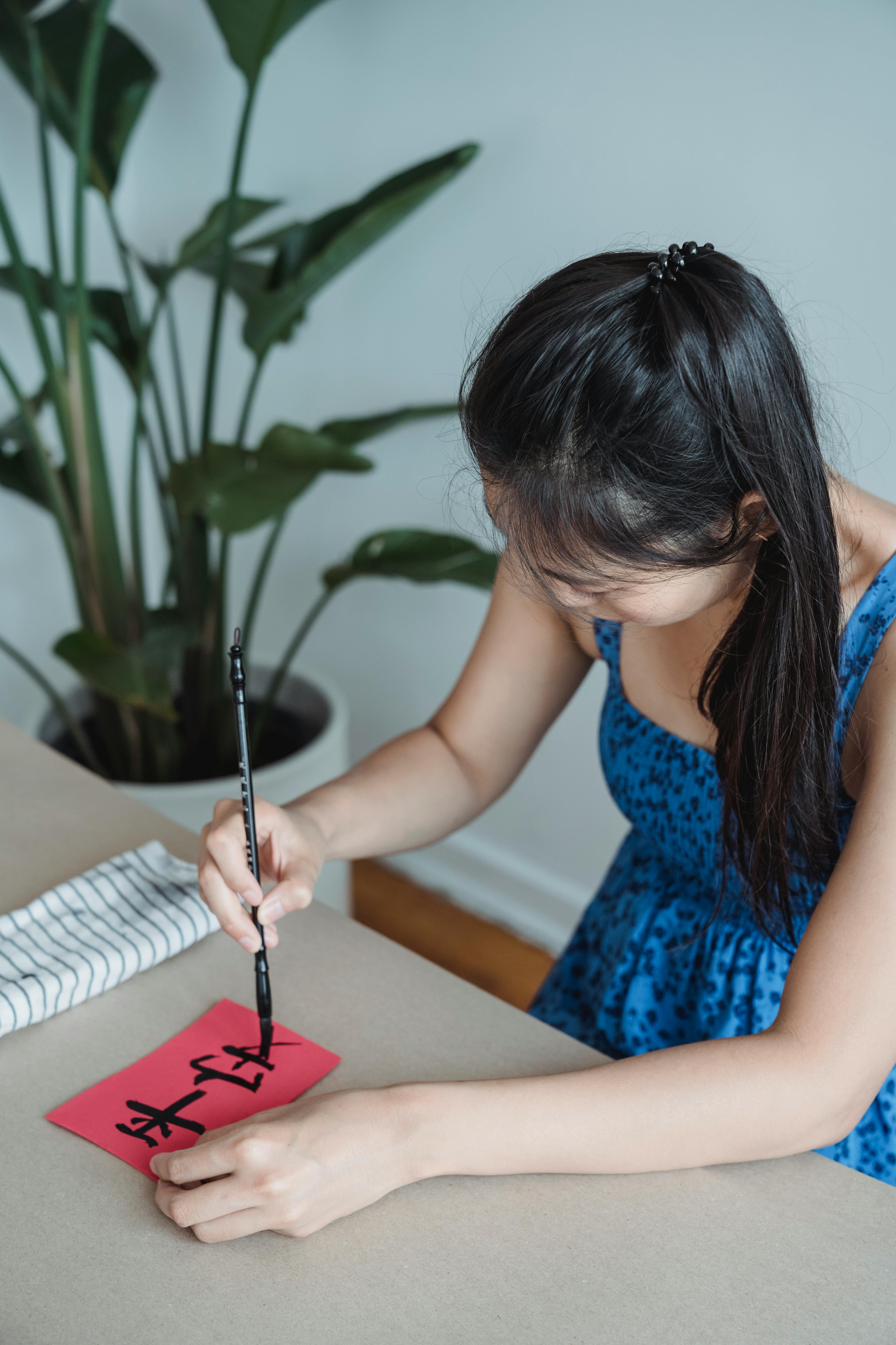 woman painting symbols on paper