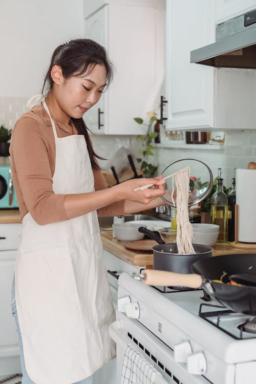 Gratis lagerfoto af asiatisk kvinde, forklæde, husarbejde Lagerfoto