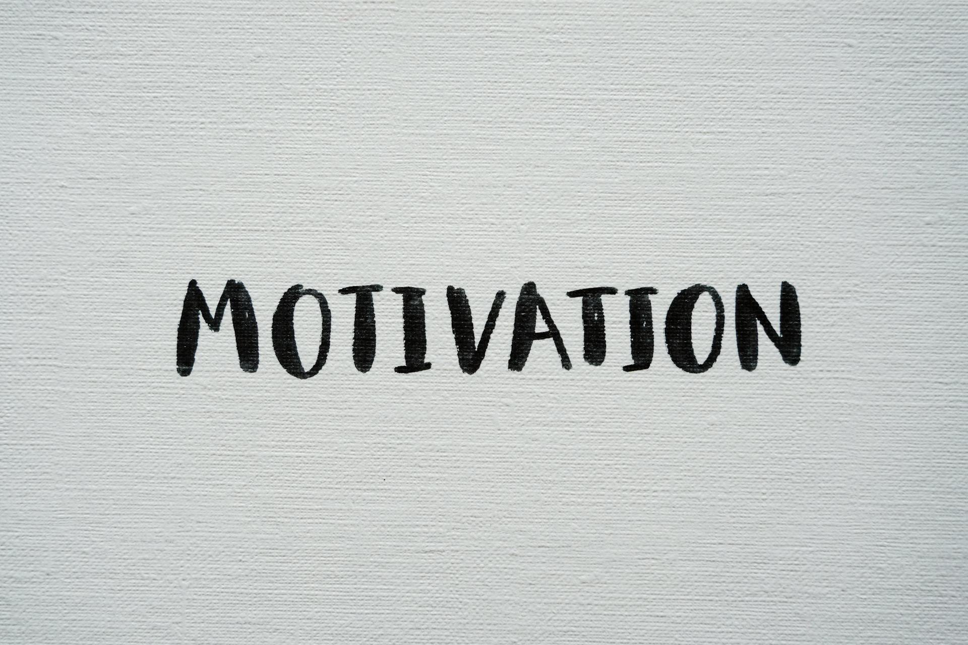 Inspirational word 'Motivation' in black on a white textured canvas background.