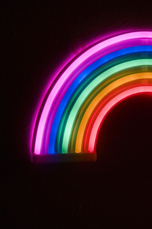 Free Colorful neon rainbow lights illuminating a dark background, perfect for modern and artistic themes. Stock Photo