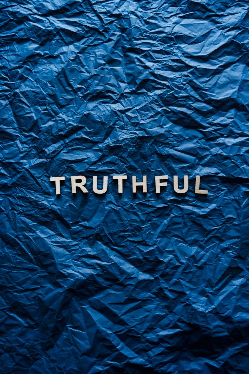 Free The word 'truthful' displayed on crumpled blue paper background. Stock Photo