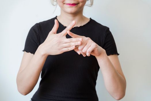 A woman making sign language gestures in a close-up shot indoors.