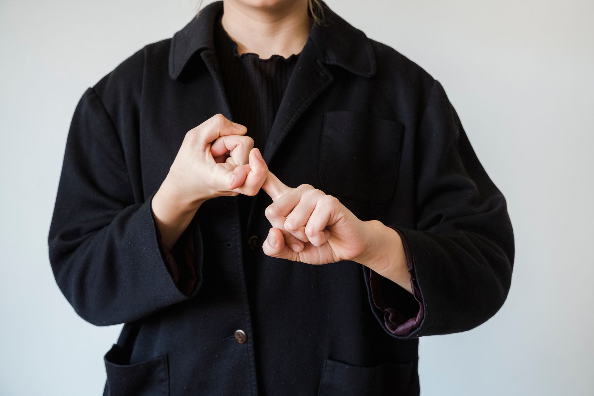 A Person in Black Coat doing Sign Language