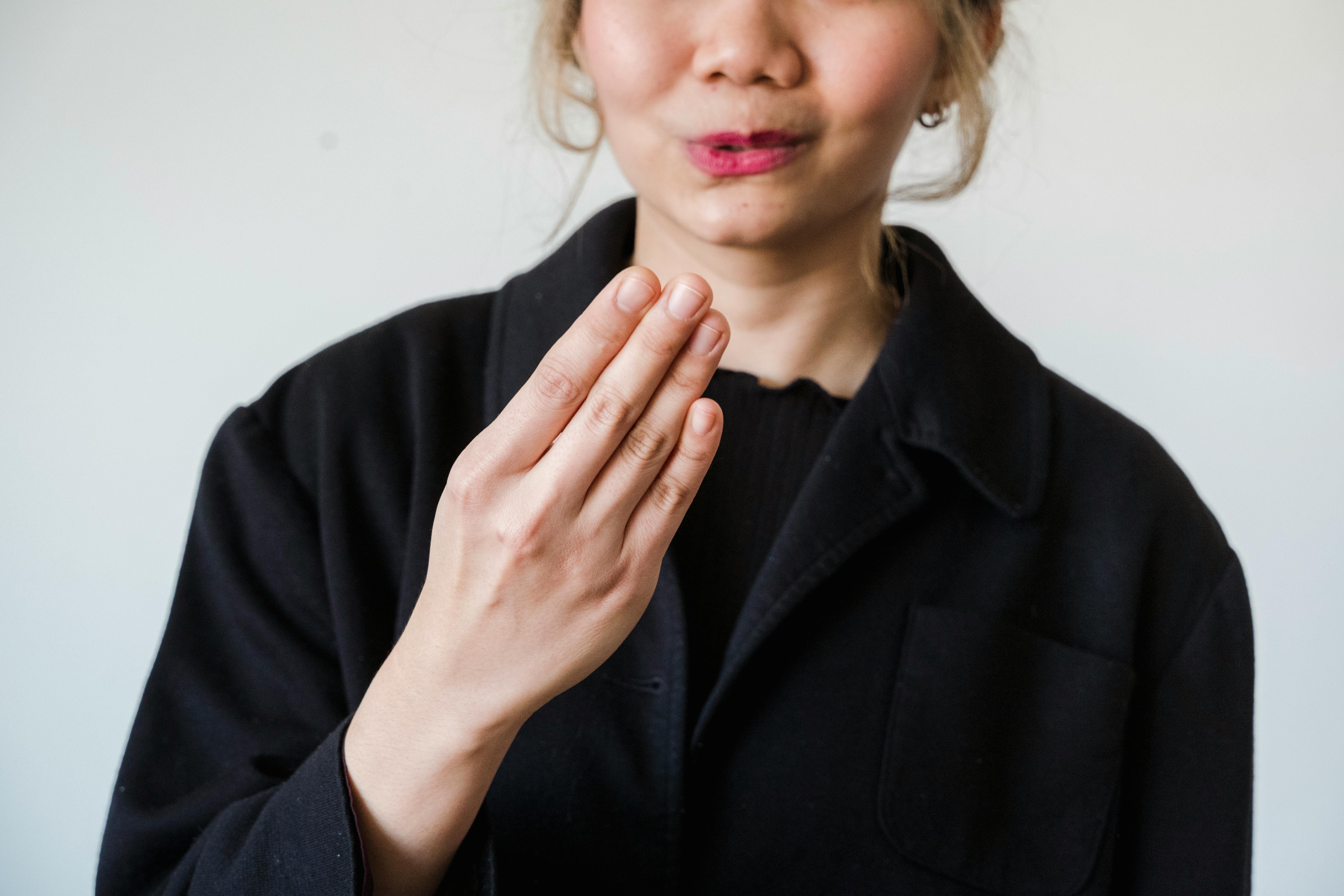 Göz teması kuran, açık avuç içleriyle konuşan ve güven telkin eden samimi bir gülümsemeye sahip dürüst bir kişinin beden dili hareketleri.