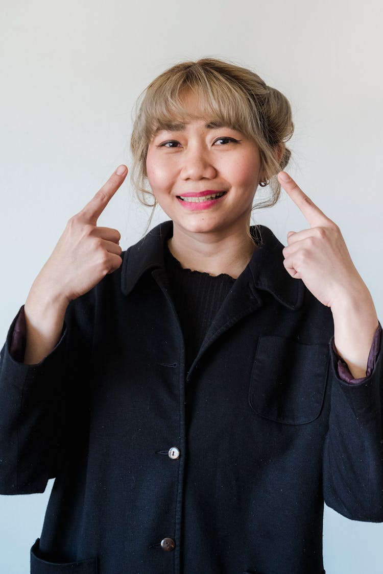 Blonde Woman Pointing Her Face With Fingers