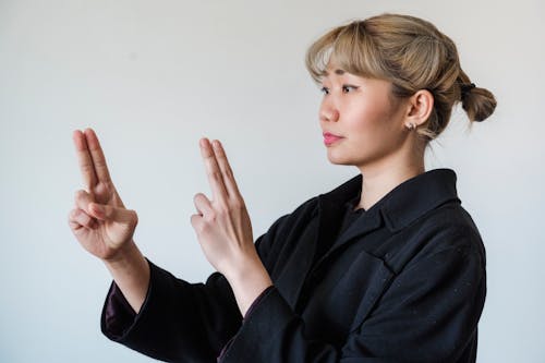 Woman in Coat Making Hand Gesture