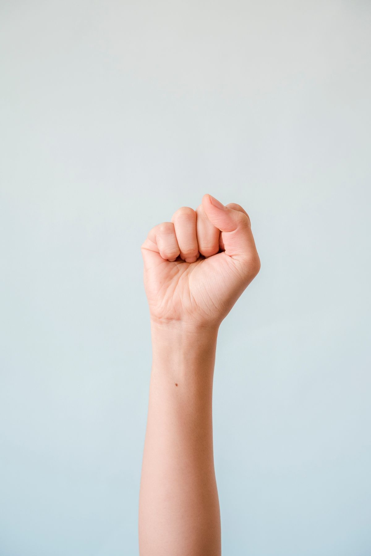 Close-up of a clenched fist, symbolizing the grip and restriction of a scarcity money mindset