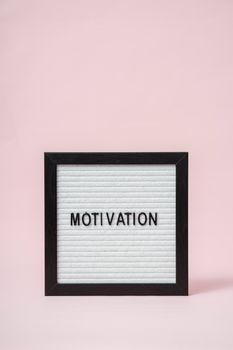 A letter board with 'Motivation' text on a soft pink background, perfect for inspirational themes.