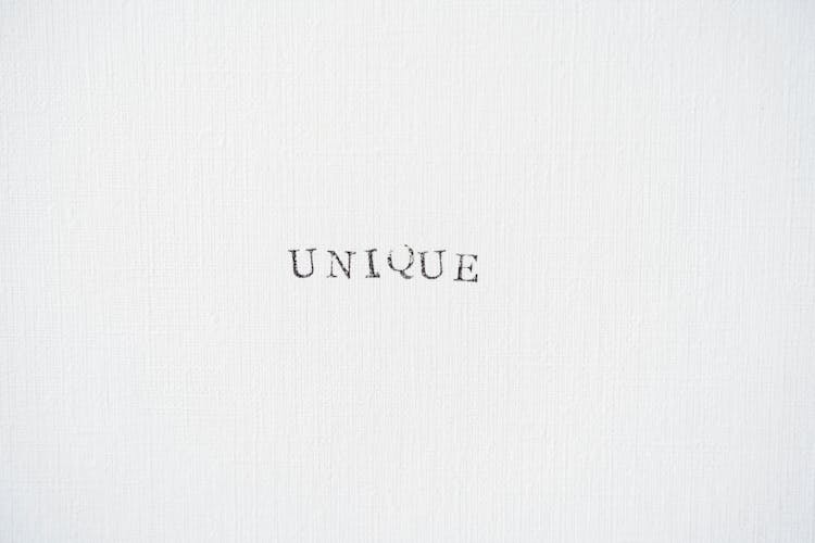 Word Unique Written With Ink Stamps On Canvas 