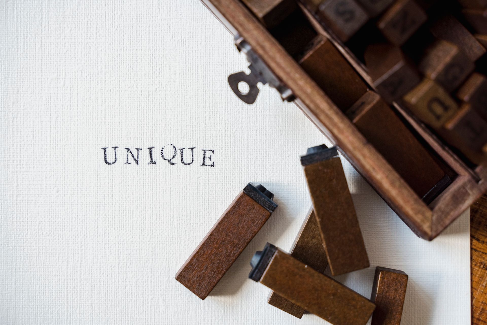 Brown Wooden Case of Letter Blocks and White Paper Stamped With Text