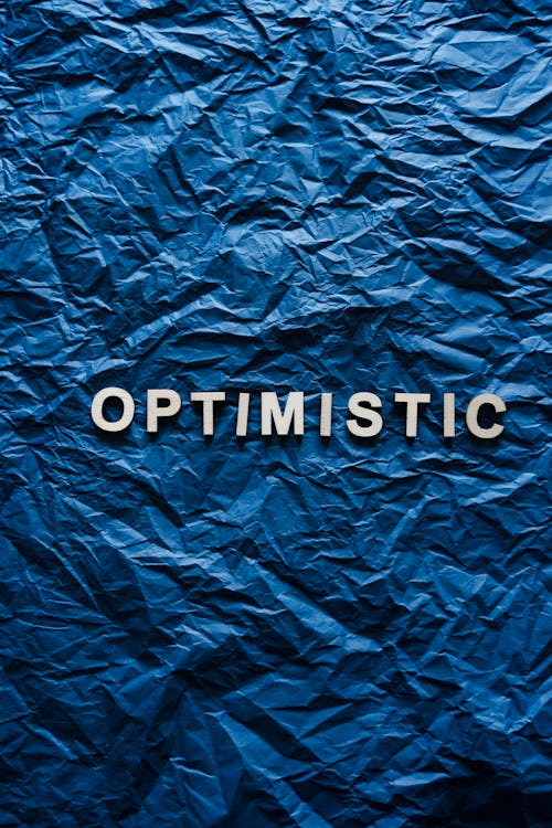 Free The Word Optimistic on Crumpled Paper Stock Photo