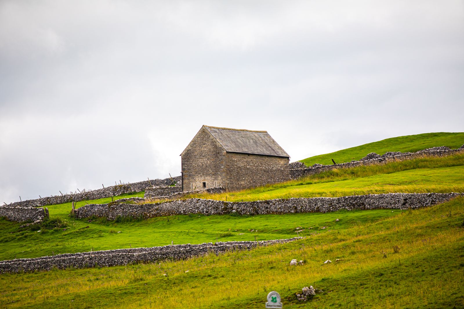 A stone barn on a green hillside in the Yorkshire Dales