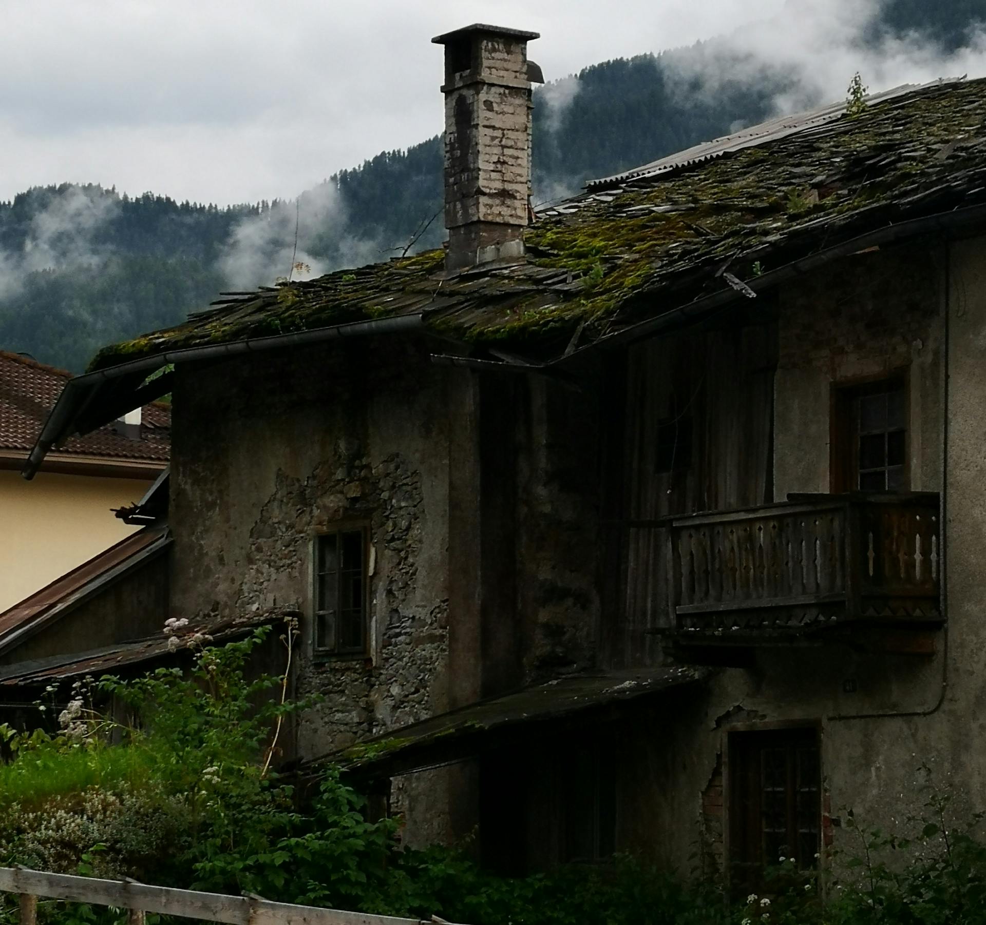 Abandoned House with Chimney and Moss on the Roof