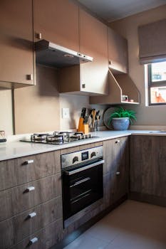 Stylish kitchen with wooden cabinets, gas stove, and modern decor in South Africa.