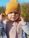 Baby in Orange Knit Cap and Blue and White Striped Long Sleeve Shirt