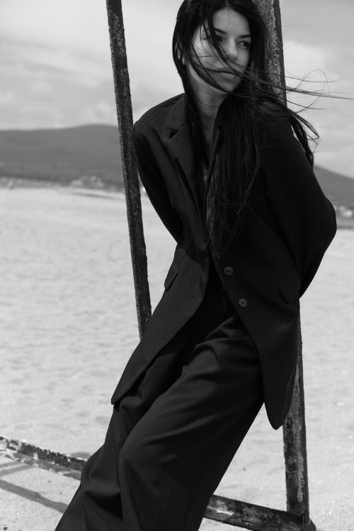 Free Black and white portrait of a woman in a suit on the beach, windswept hair. Stock Photo