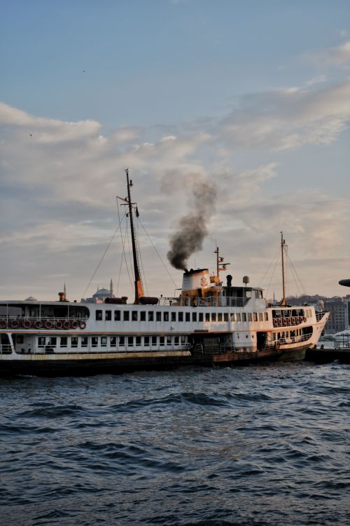 Free A scenic view of a traditional ferry sailing on the Bosphorus in Istanbul during twilight. Stock Photo