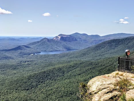 从悬崖上望去，山区景观令人叹为观止，郁郁葱葱的森林和遥远的湖泊尽收眼底