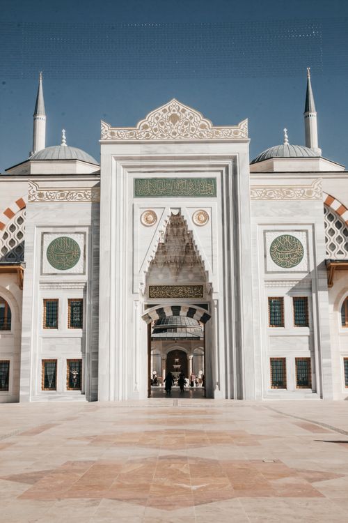 Free Stunning architectural shot of a mosque entrance with intricate designs and blue skies. Stock Photo