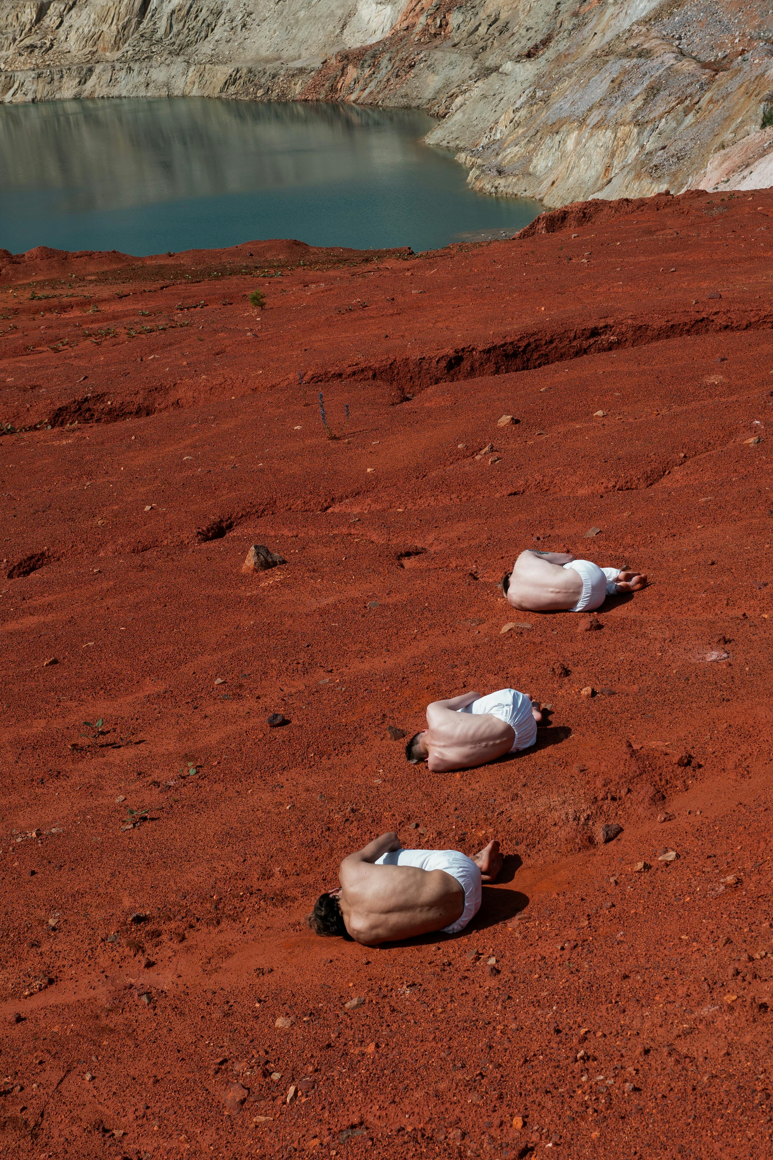 people in white pants lying on brown sand