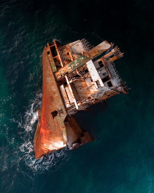 Free An Old Rusty Ship Floating on the Sea Stock Photo
