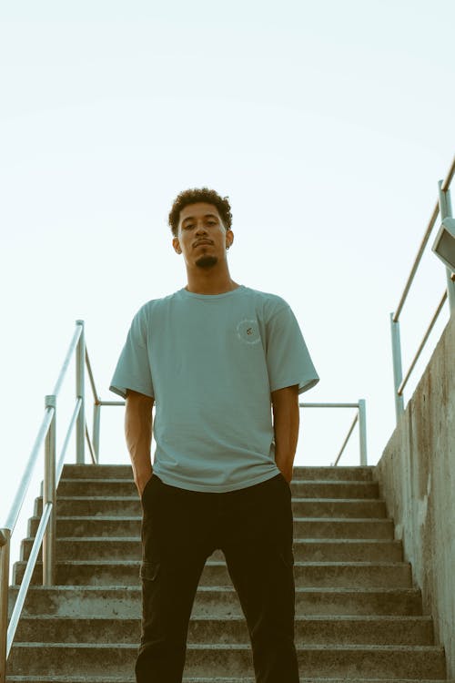 Man in White Crew Neck T-shirt Standing on Stairs