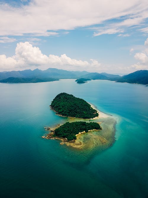 Green Trees on Island Surrounded by Water Under White Clouds and Blue Sky