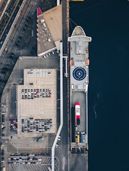 Aerial shot of a cargo ship docked at Barcelona port, showcasing the harbor's industrial setup.