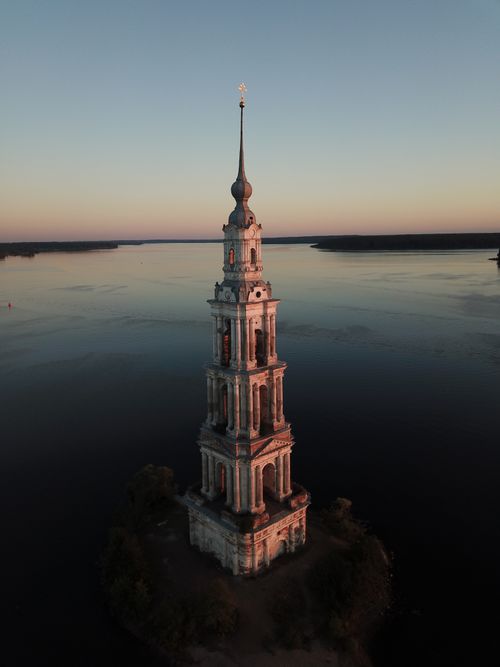 Free Aerial view of the historic Kolomna Bell Tower at twilight surrounded by calm waters. Stock Photo