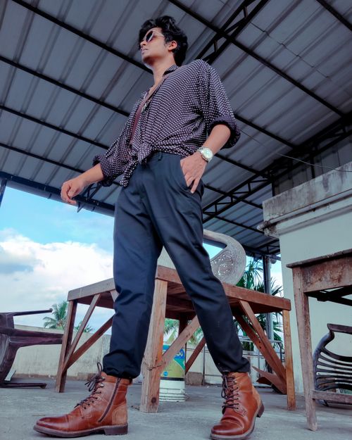 Free Low-angle shot of a stylish man in urban fashion posing outdoors. Stock Photo