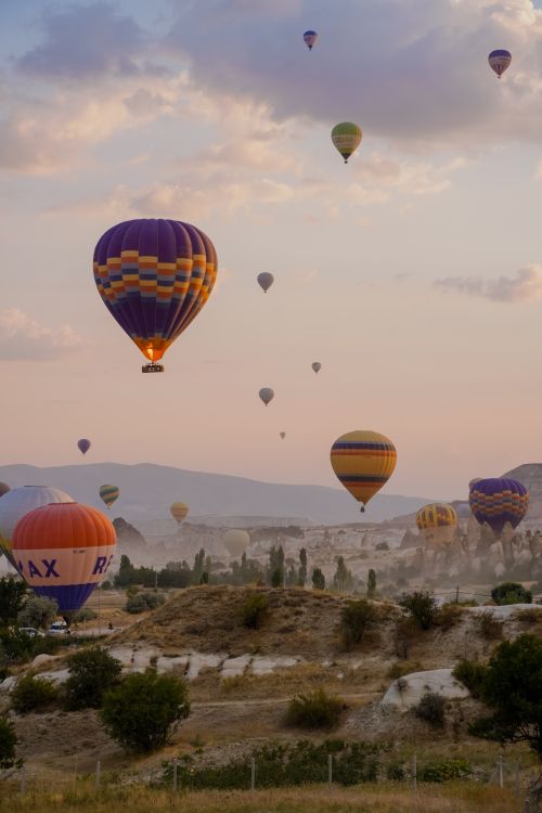 Free Stunning view of hot air balloons floating over Cappadocia's unique landscape during sunrise. Stock Photo