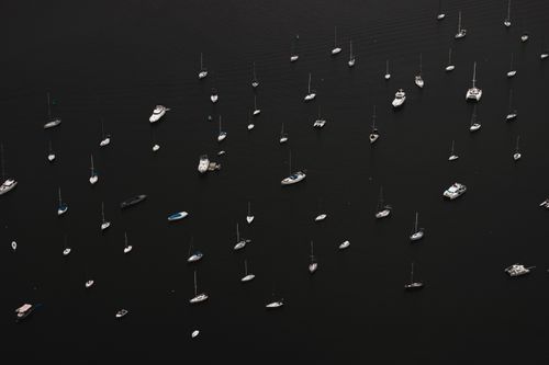 Free Aerial photograph of numerous sailboats scattered across the dark waters in Rio de Janeiro, Brazil. Stock Photo