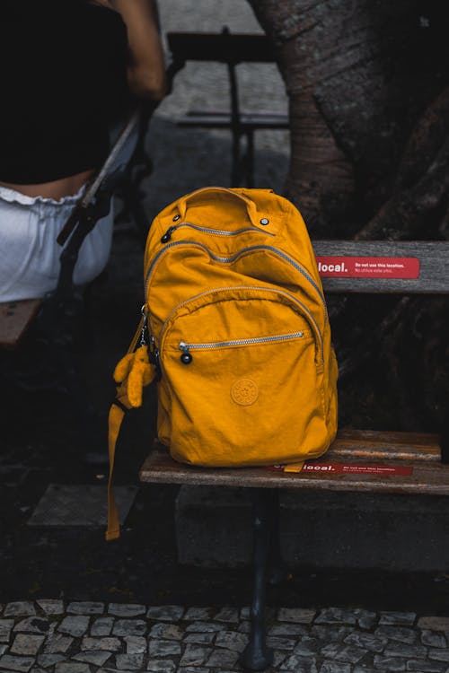 Yellow Backpack on a Bench