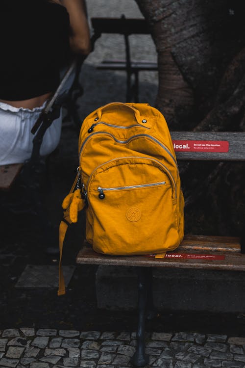 Free Yellow Backpack on a Bench Stock Photo