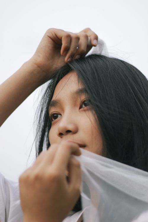 Free Close-up portrait capturing the elegance and poise of a young woman with flowing black hair. Stock Photo