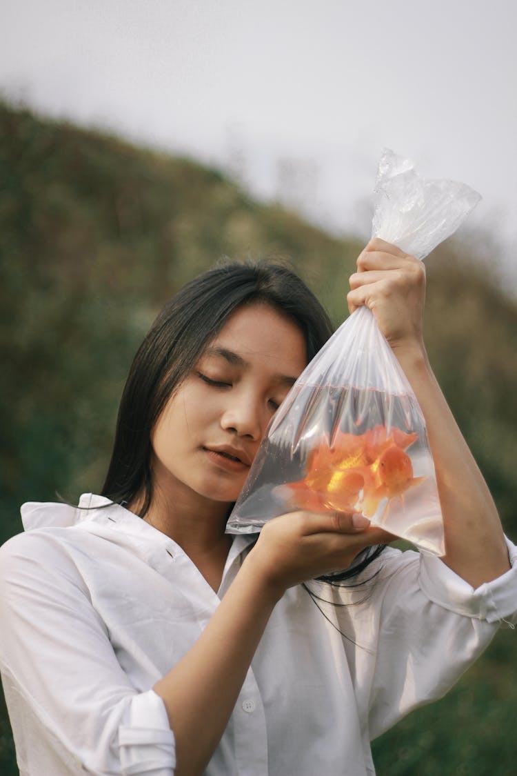 Woman Holding A Plastic Bag With Goldfish