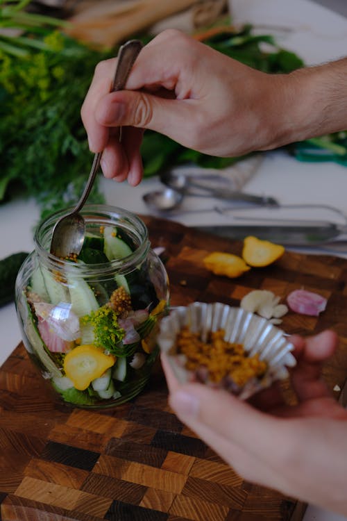 Free Person Putting Ingredients in a Glass Jar for Fermentation Stock Photo