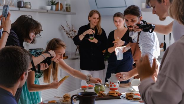 A group of friends capturing moments while enjoying a meal in a cozy indoor setting.