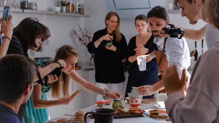 People Taking Photo Of Food On The Table