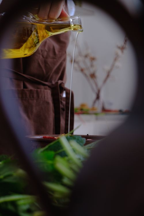 Aceite vegetal vertido desde un frasco de vidrio