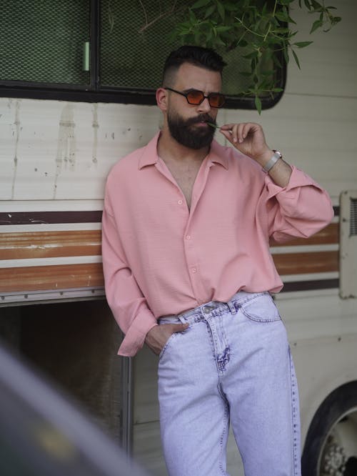 Man in Pink Dress Shirt and Blue Denim Jeans Wearing Sunglasses