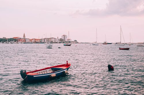 Free Serene coastal scene with boats near a Croatian town, captured in tranquil evening light. Stock Photo