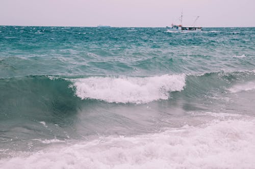 White Boat on Sea With Crashing Waves