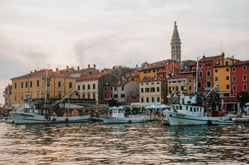 Free Scenic view of Rovinj's vibrant waterfront with boats at sunset, capturing the charm of this Croatian town. Stock Photo