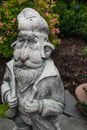Gray Dwarf Concrete Statue Near Green Plants