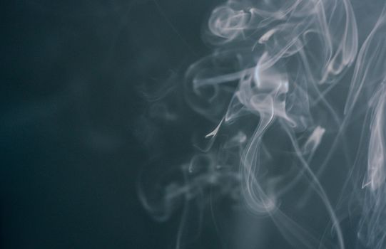 Close-up of swirling smoke patterns on a dark background, ideal for wallpapers.