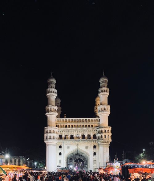 Free A captivating night view of Hyderabad's iconic Charminar monument with bustling street life. Stock Photo
